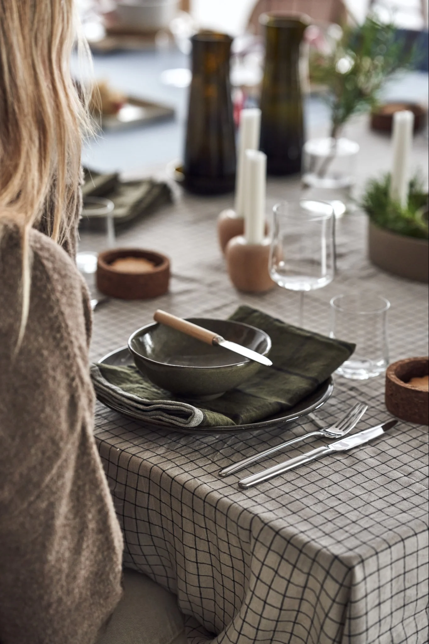 Christmas tablescape in the cultivate style with lots of natural materials and dark green tones.