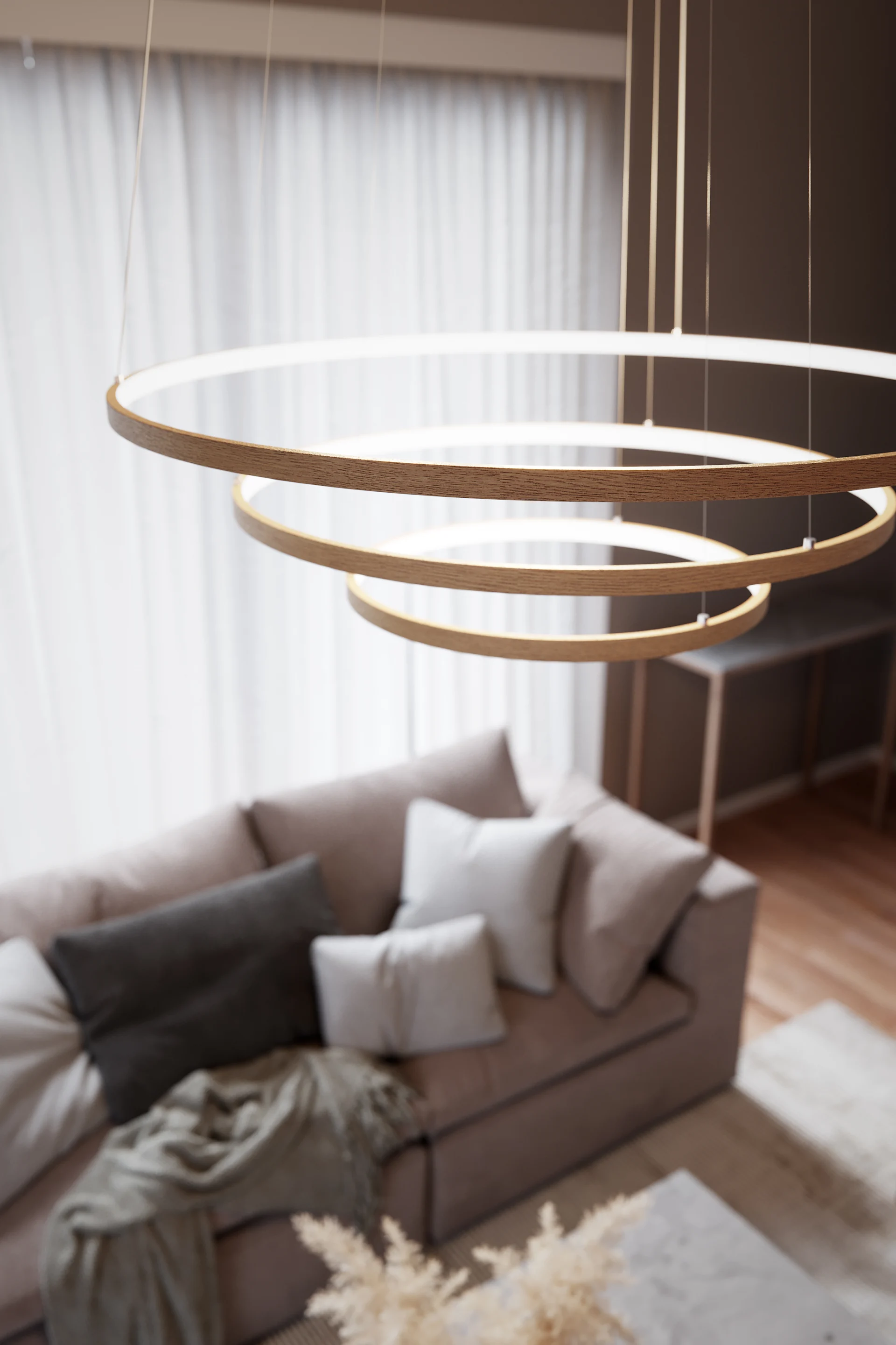 Overhead view of a modern living room featuring a multi-ringed wooden pendant light with LED illumination, a beige sofa, and a coffee table.