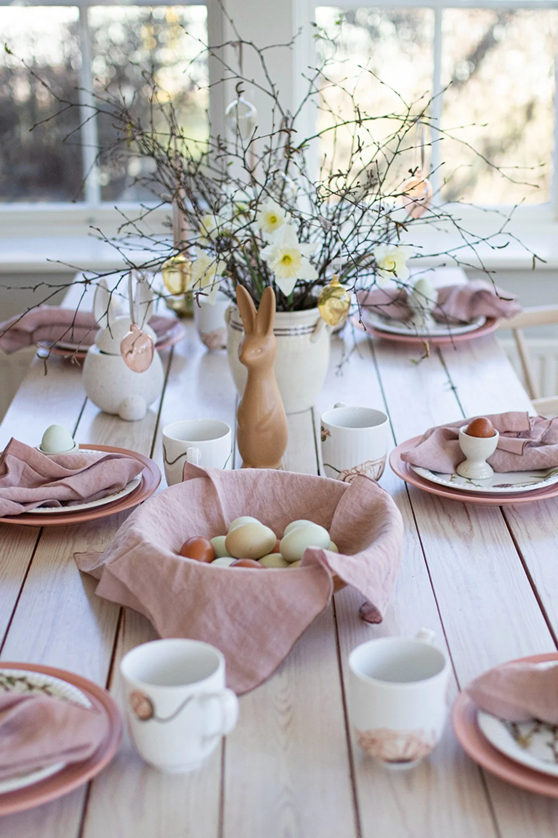 Here you see an Easter table setting idea from Swedish influence @colorelles with tones of pastel pink and an Easter tree.